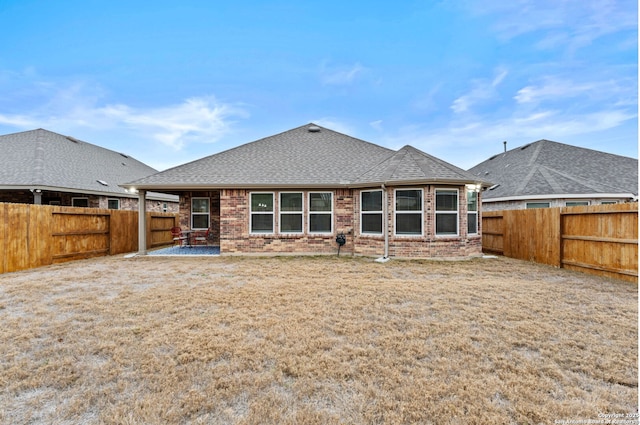 back of house featuring a patio and a lawn