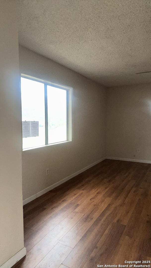 521 Quail Ln, Floresville, TX 78114 - empty room featuring hardwood / wood-style floors and a textured ceiling
