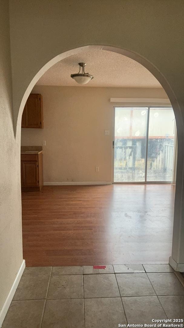 521 Quail Ln, Floresville, TX 78114 - tiled empty room featuring a textured ceiling