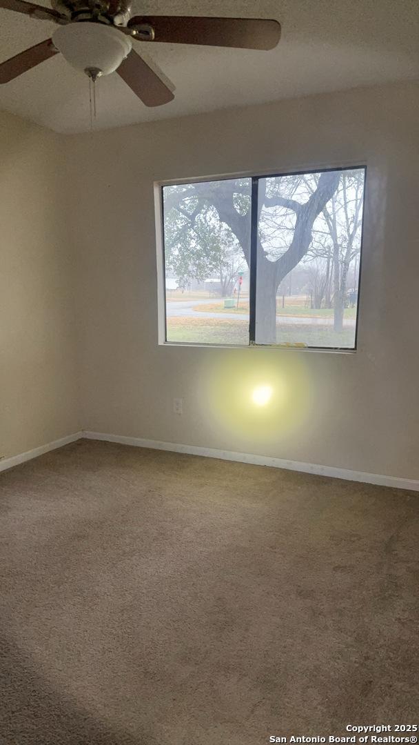 521 Quail Ln, Floresville, TX 78114 - spare room with carpet flooring, a wealth of natural light, and ceiling fan