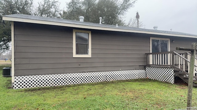 521 Quail Ln, Floresville, TX 78114 - view of home's exterior with central AC unit and a lawn