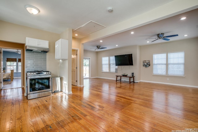 kitchen featuring white cabinetry, tasteful backsplash, light hardwood / wood-style flooring, stainless steel range, and ceiling fan