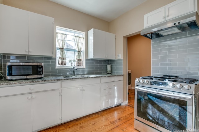 kitchen featuring white cabinetry, sink, stainless steel appliances, light stone countertops, and light wood-type flooring