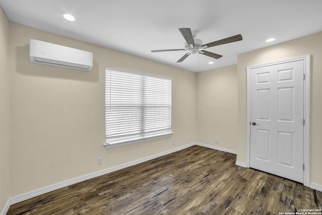 spare room featuring dark hardwood / wood-style flooring, an AC wall unit, and ceiling fan