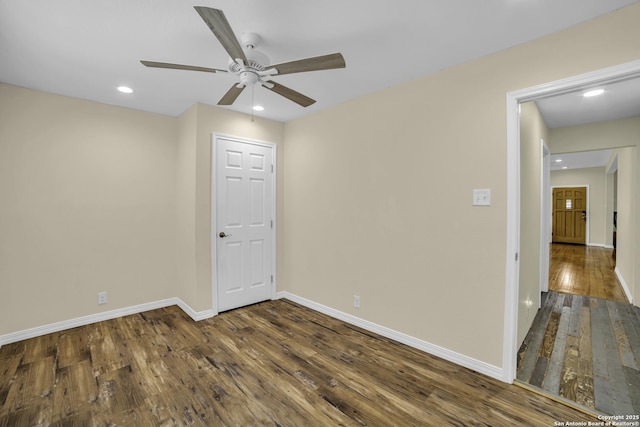 empty room with dark wood-type flooring and ceiling fan