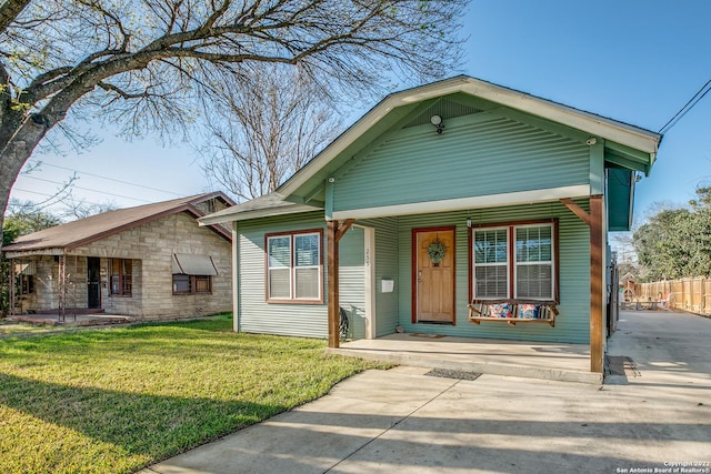 view of front of home with covered porch and a front lawn