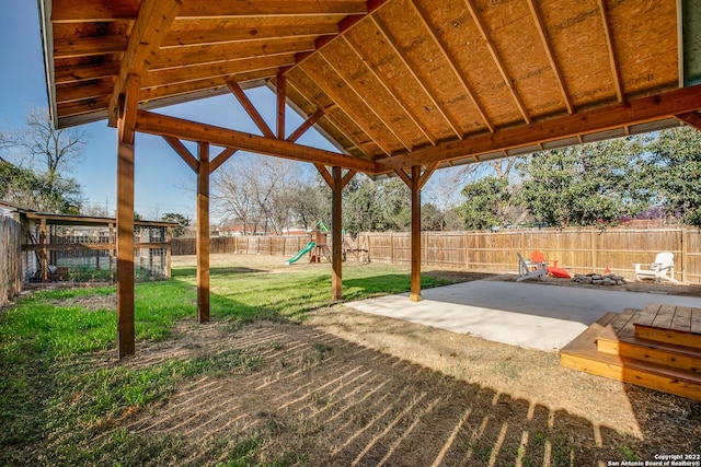 view of patio featuring a playground and an outdoor fire pit