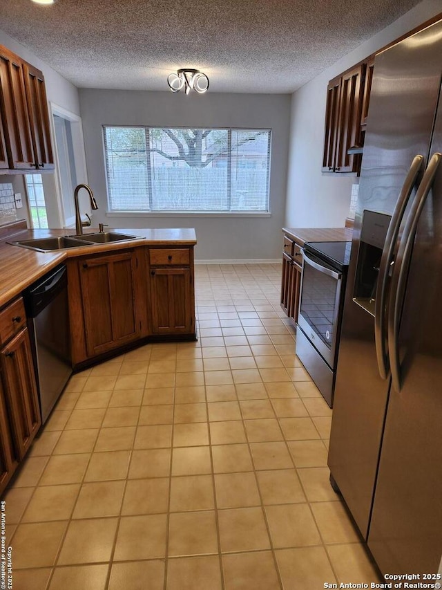 kitchen featuring sink, light tile patterned floors, a wealth of natural light, and stainless steel appliances