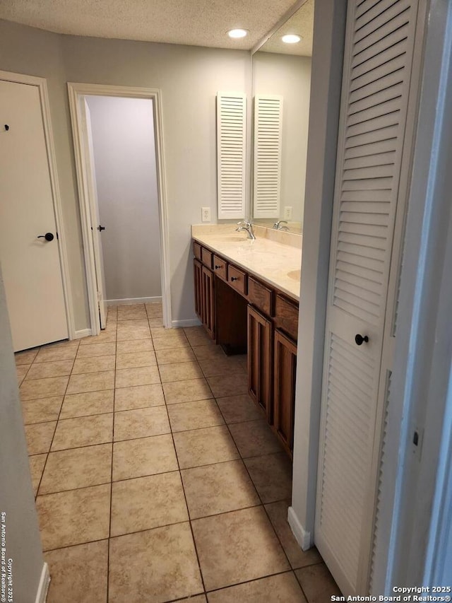 bathroom featuring tile patterned floors, vanity, and a textured ceiling