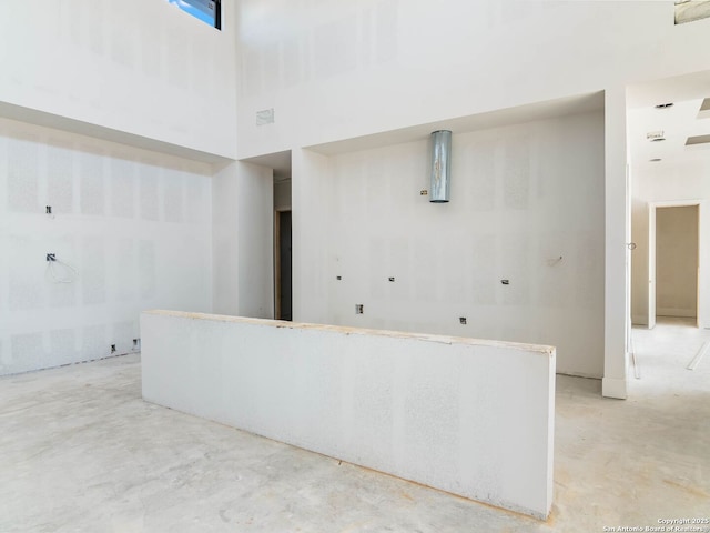 interior space featuring a high ceiling and concrete floors