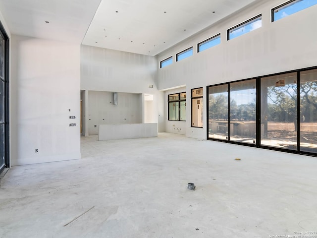 unfurnished living room with a healthy amount of sunlight and a high ceiling