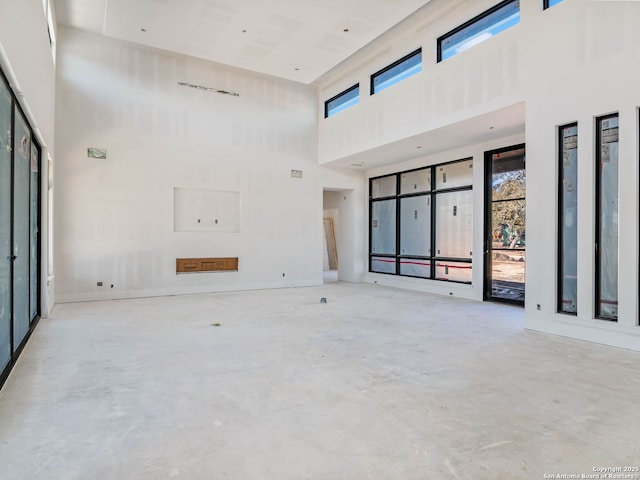 unfurnished living room with a healthy amount of sunlight and a high ceiling