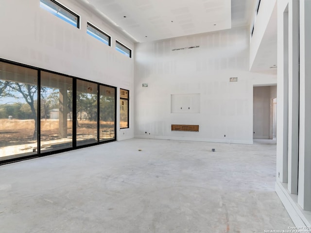 unfurnished living room with a high ceiling and plenty of natural light