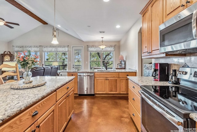 kitchen featuring sink, light stone counters, decorative light fixtures, stainless steel appliances, and decorative backsplash