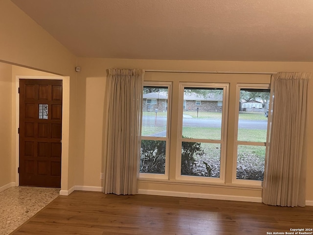 entrance foyer with vaulted ceiling and dark hardwood / wood-style floors