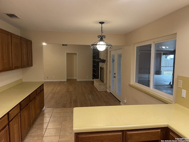 kitchen with pendant lighting, a brick fireplace, and light tile patterned flooring