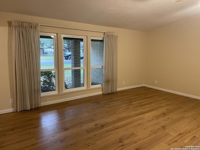 unfurnished room with hardwood / wood-style flooring