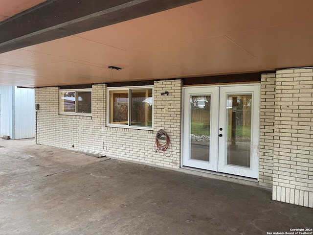 view of exterior entry featuring french doors and a patio area