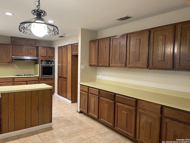 kitchen with hanging light fixtures, black oven, gas cooktop, and light tile patterned flooring