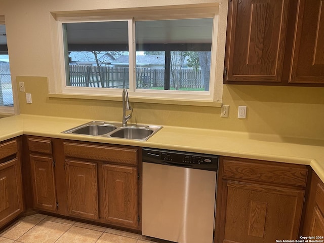 kitchen with light tile patterned flooring, dishwasher, and sink