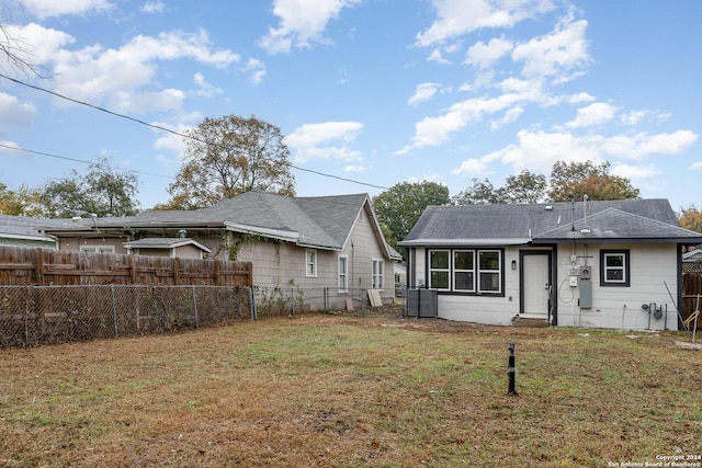 back of house featuring cooling unit and a lawn