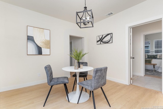 dining area with a chandelier and light hardwood / wood-style floors