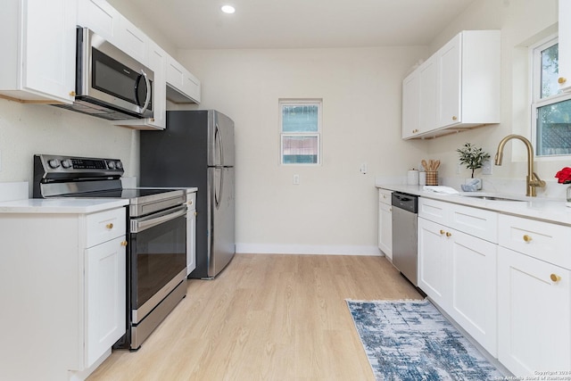 kitchen with stainless steel appliances, sink, and white cabinets