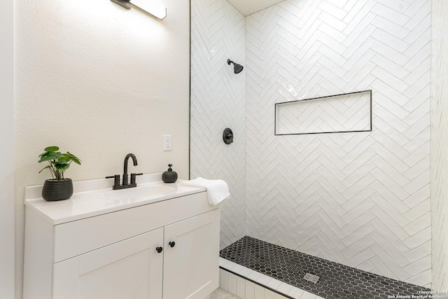 bathroom featuring vanity and tiled shower