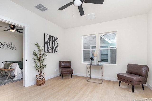 living area with ceiling fan and light wood-type flooring