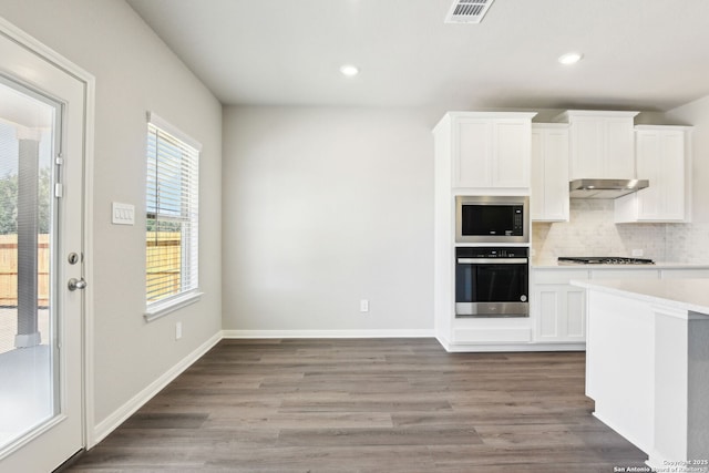 kitchen with tasteful backsplash, light wood-style floors, visible vents, and stainless steel appliances