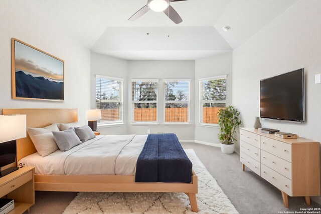 bedroom featuring baseboards, light carpet, lofted ceiling, and ceiling fan