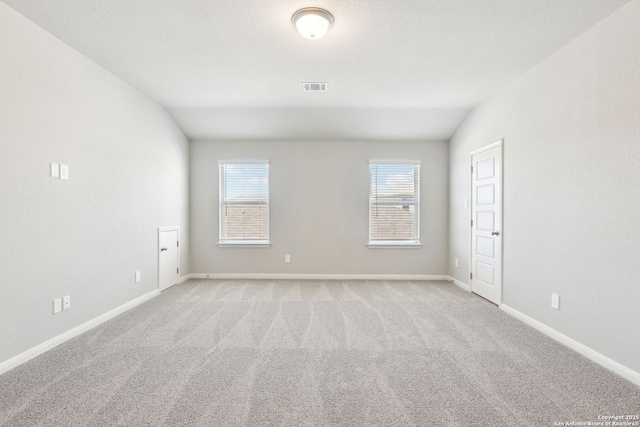 empty room with baseboards, a healthy amount of sunlight, visible vents, and light carpet