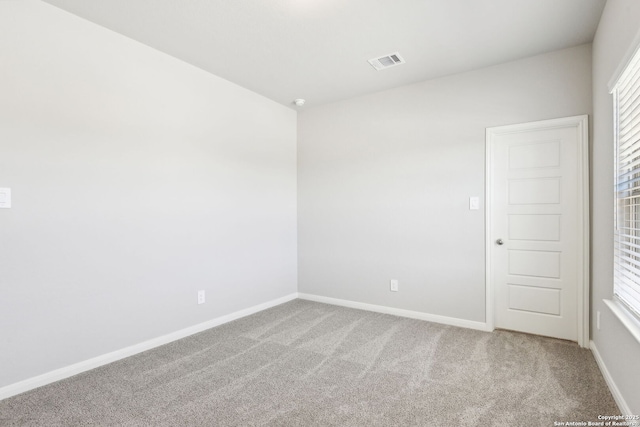 spare room featuring visible vents, baseboards, and carpet flooring