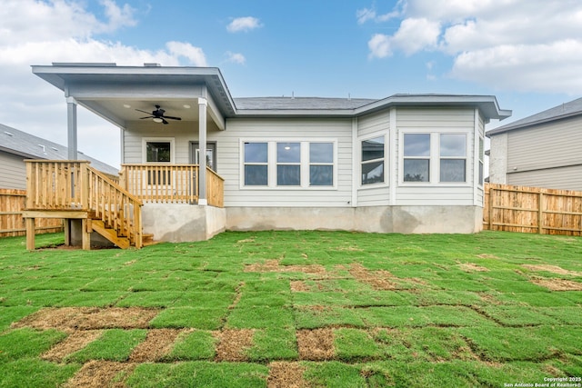 rear view of house with ceiling fan and a lawn