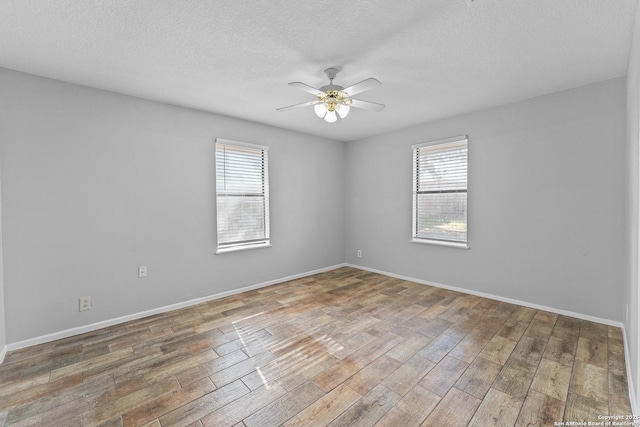 spare room with hardwood / wood-style floors, a textured ceiling, and ceiling fan