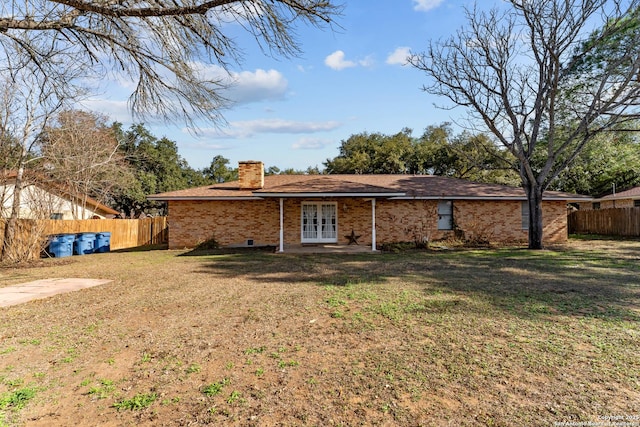 back of house with french doors and a yard