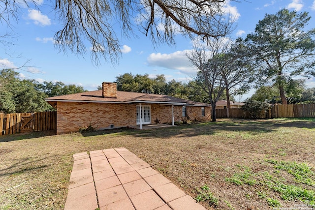 back of property featuring french doors, a patio, and a lawn