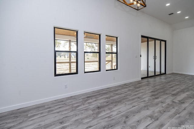 unfurnished room featuring light hardwood / wood-style flooring and a notable chandelier