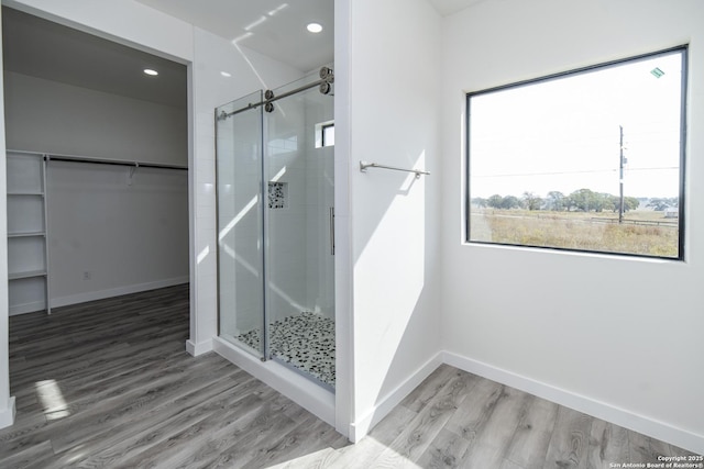 bathroom featuring wood-type flooring and a shower with door