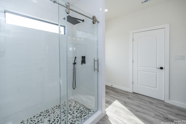 bathroom featuring hardwood / wood-style floors and a shower with door