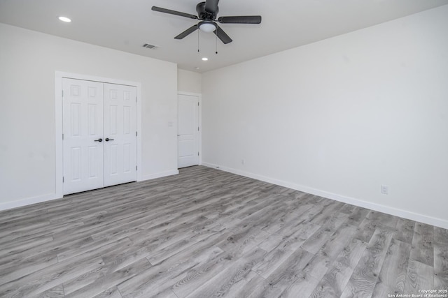 unfurnished bedroom with light hardwood / wood-style flooring, a closet, and ceiling fan