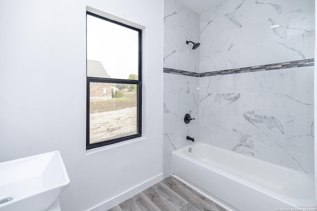 bathroom featuring sink, tiled shower / bath combo, and wood-type flooring