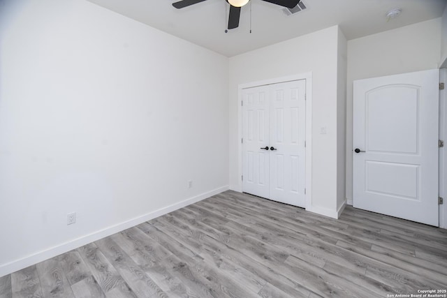 unfurnished bedroom featuring ceiling fan, light wood-type flooring, and a closet