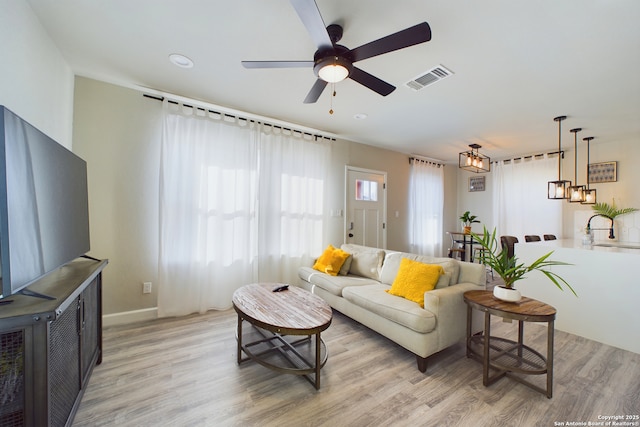 living room featuring light hardwood / wood-style floors and ceiling fan