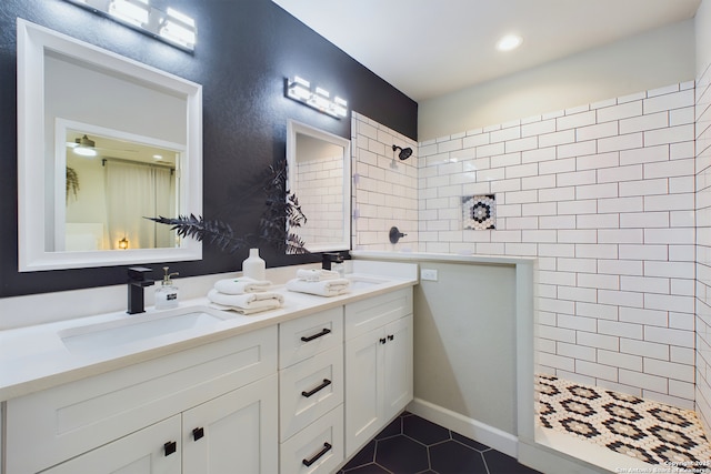 bathroom featuring a tile shower, vanity, and tile patterned flooring