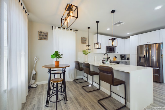 kitchen with stainless steel appliances, sink, a breakfast bar area, and kitchen peninsula
