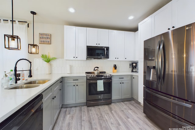 kitchen with sink, gray cabinets, appliances with stainless steel finishes, hanging light fixtures, and white cabinets