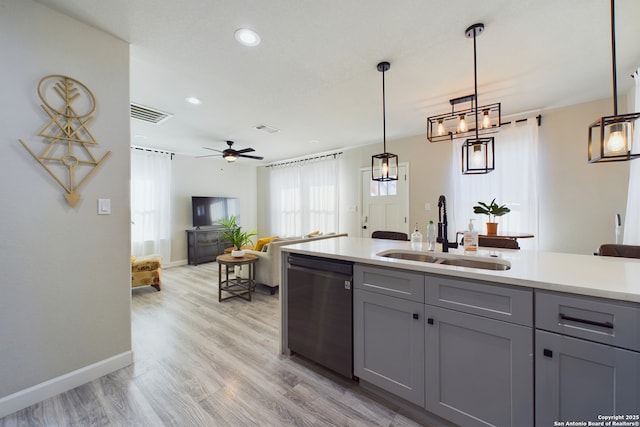 kitchen with sink, gray cabinetry, hanging light fixtures, stainless steel dishwasher, and light wood-type flooring
