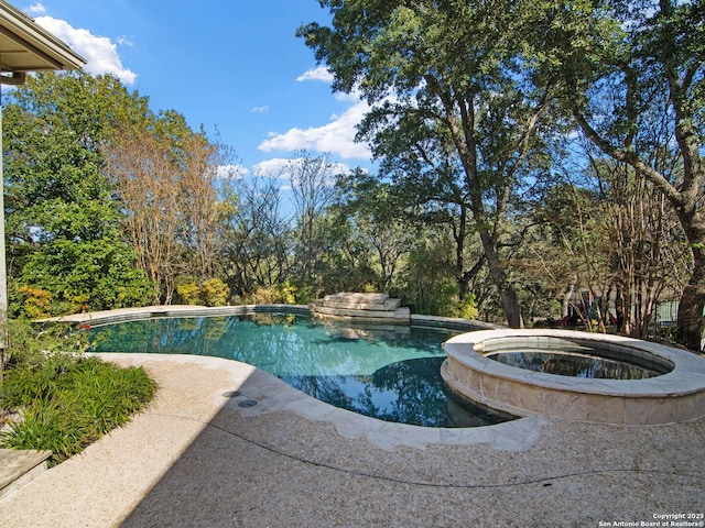 view of pool with an in ground hot tub