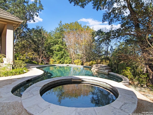 view of swimming pool with an in ground hot tub